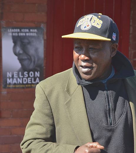 Ngugi Githuka talks with tourists outside Mandela House Museum. LBWPhoto