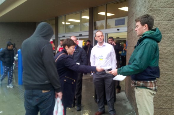 Striking Walmart worker hands out information about the nation's largest employer and its exploitive labor practices