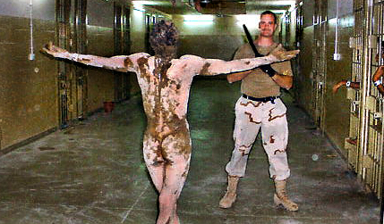An MP homosexually degrades an Iraqi detainee, while other detainees watch.